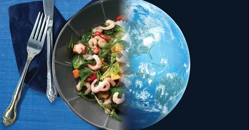 A plate of shrimp and greens merged with an image of the earth.