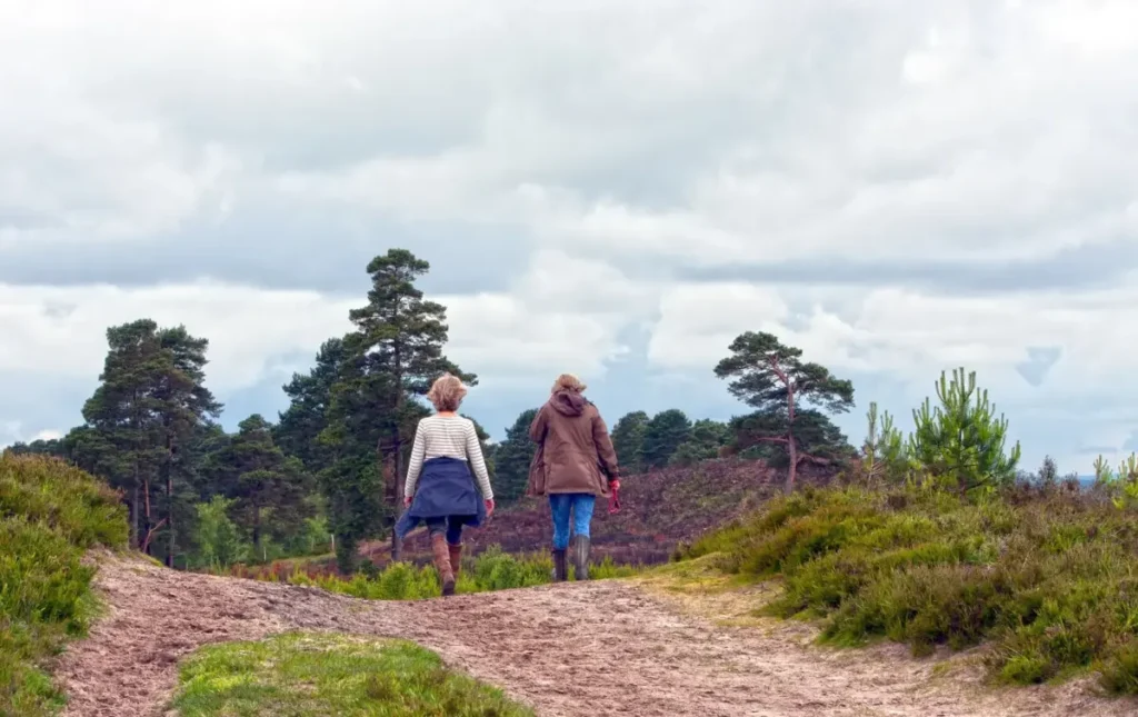 Two woman walking down a trail