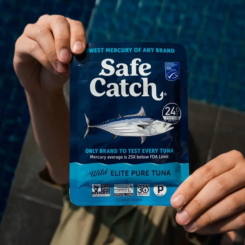 person holding up a pouch of safe catch elite pure tuna