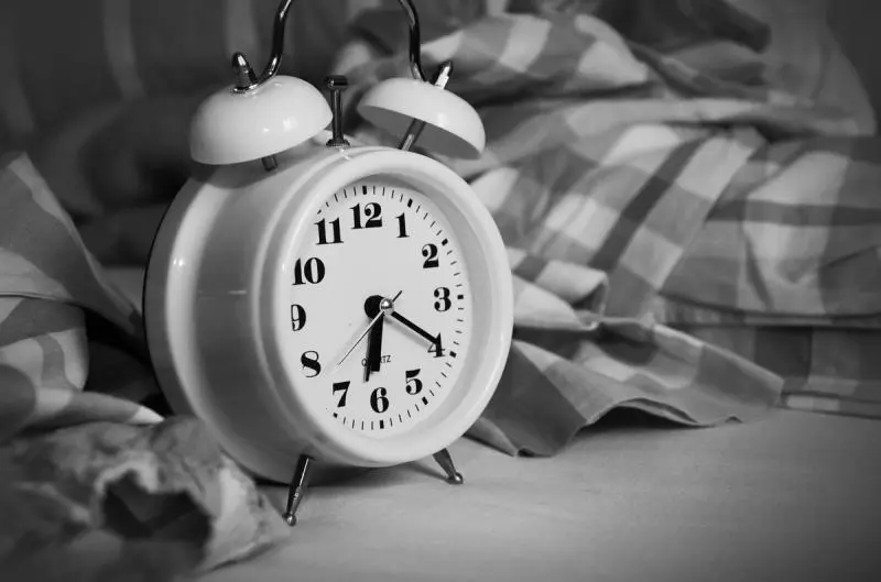 Analog alarm clock on a nightstand