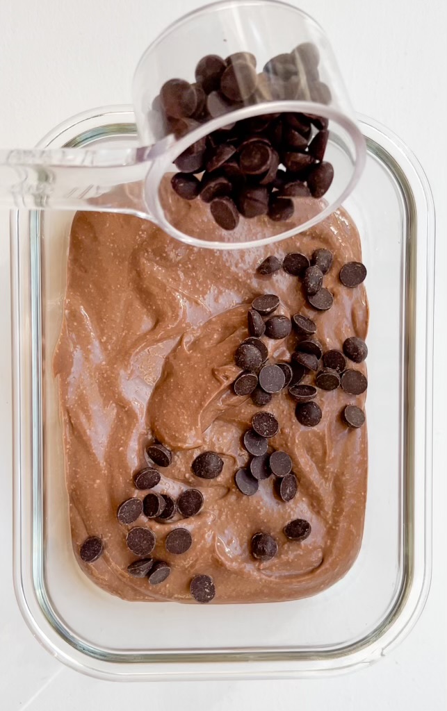 Gluten-free chocolate lava cake being topped with dark chocolate chips.