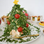 Holiday cheese ball decorated with tomatoes and herbs.