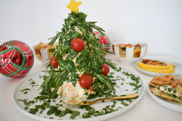 Holiday cheese ball decorated with tomatoes and herbs.