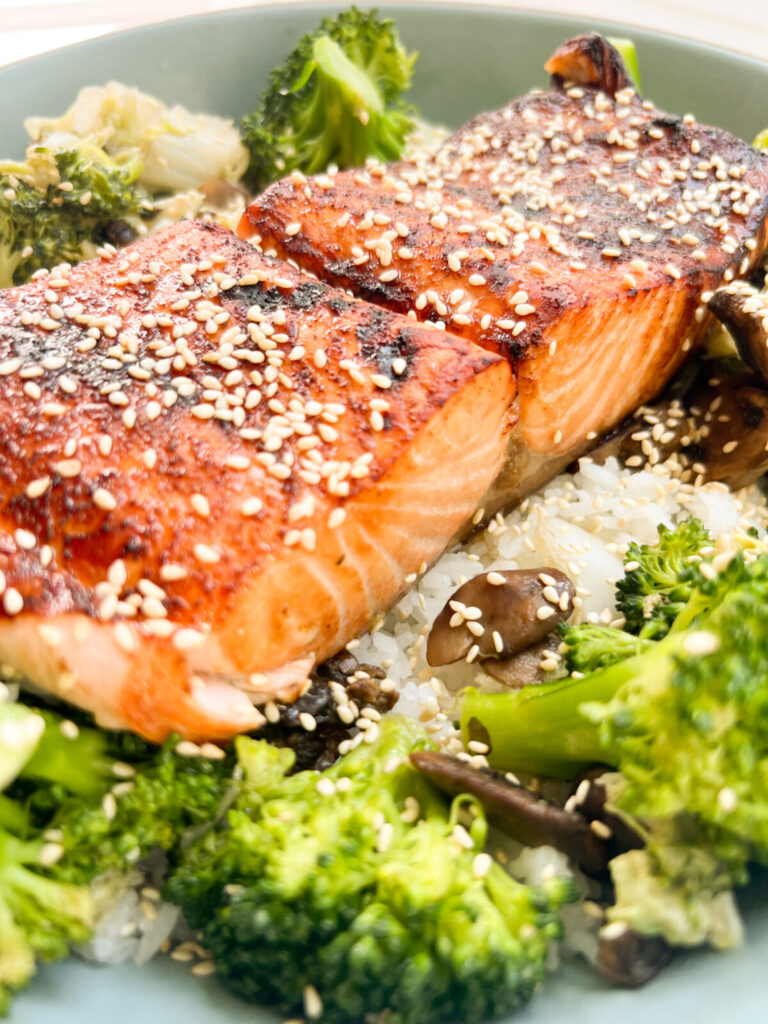 Air fryer salmon topped with sesame seeds and Asian honey sauce.