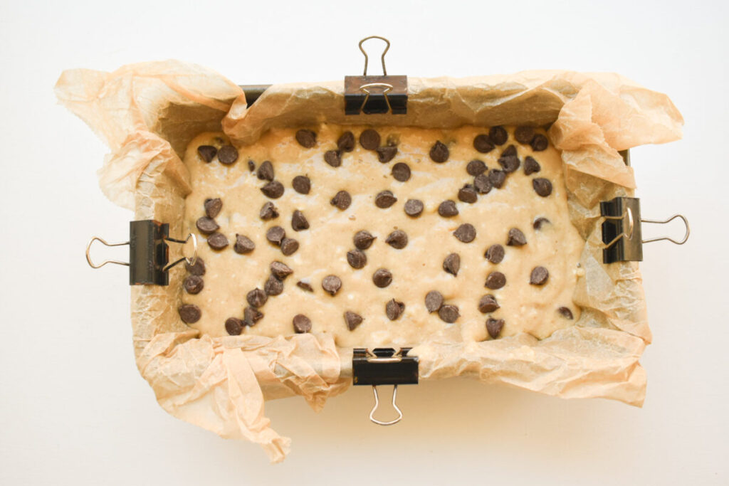 Quick bread batter in prepared load pan, topped with chocolate chips/