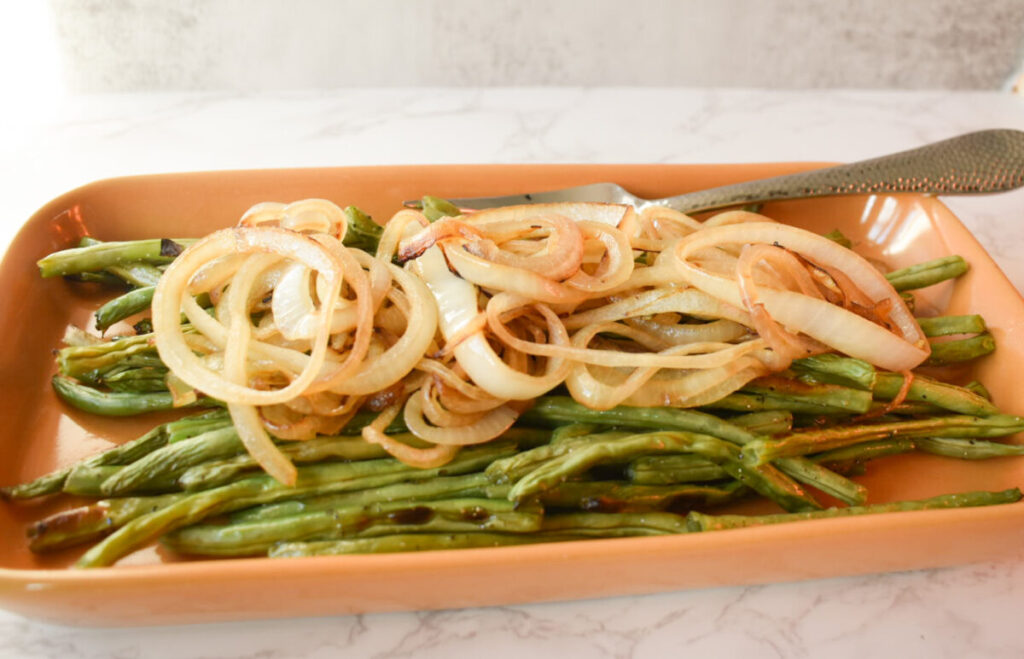 Roasted green beans topped with caramelized onions