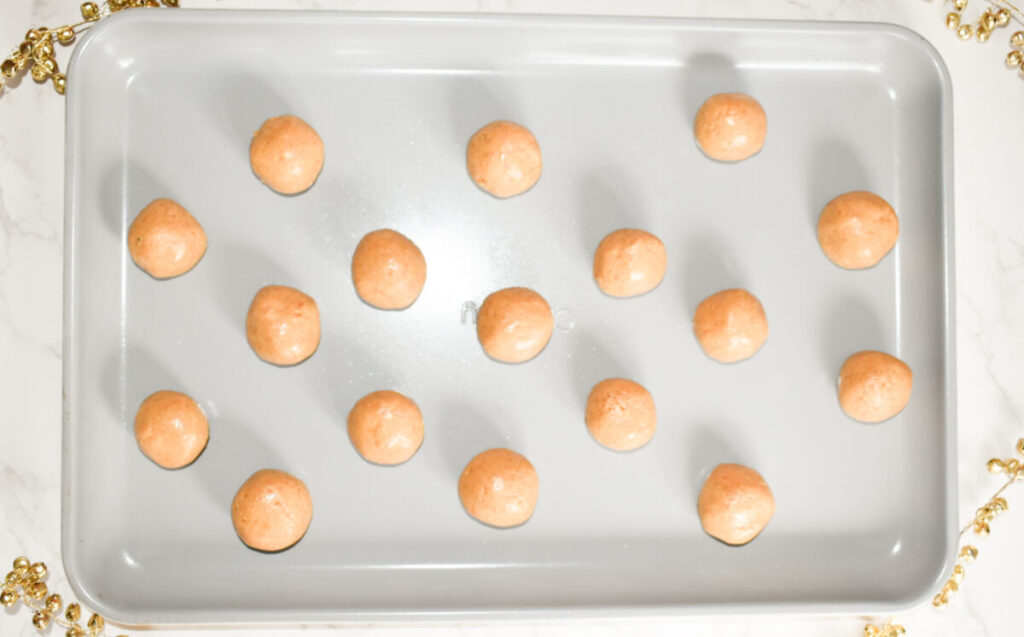 Rolled peanut butter balls on a cookie sheet