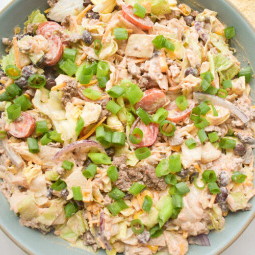 taco salad with ground beef, beans, and lettuce toppings