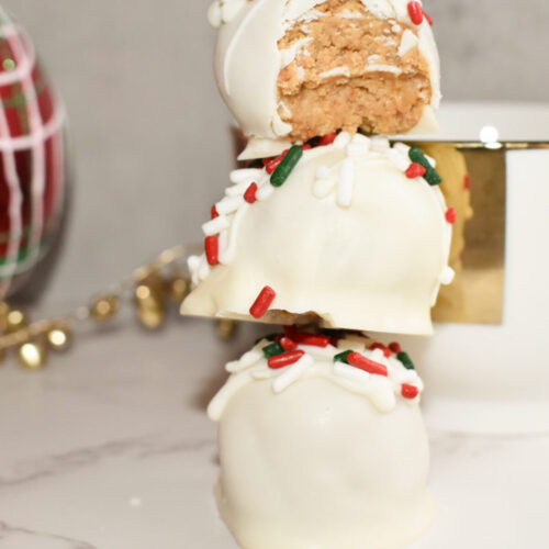 three peanut butter snowballs with green and red sprinkles