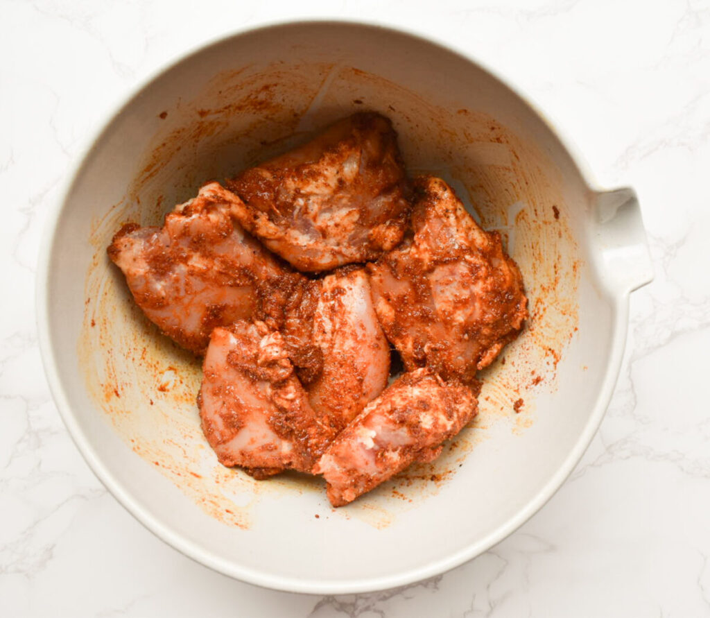 chicken thighs coated in spice mix, ready to be baked