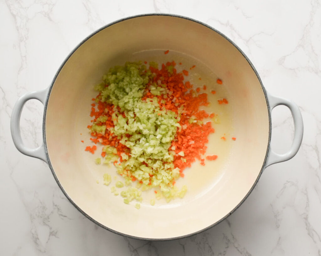 carrots and celery being cooked for broccoli cheddar soup