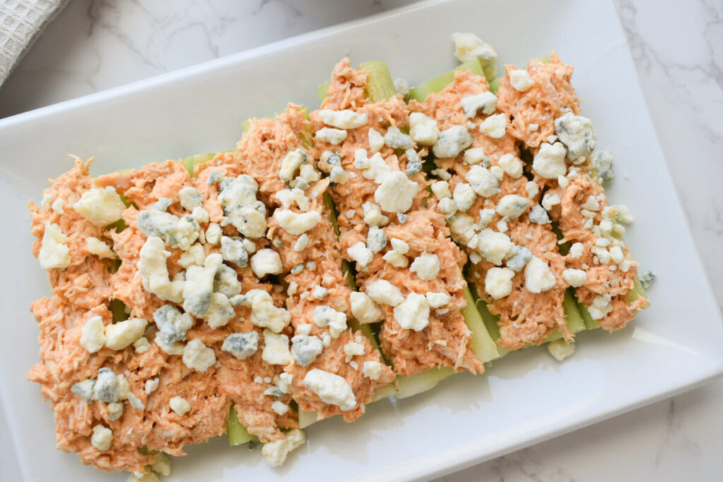 buffalo chicken over celery sticks topped with blue cheese