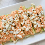 buffalo chicken over celery sticks topped with blue cheese