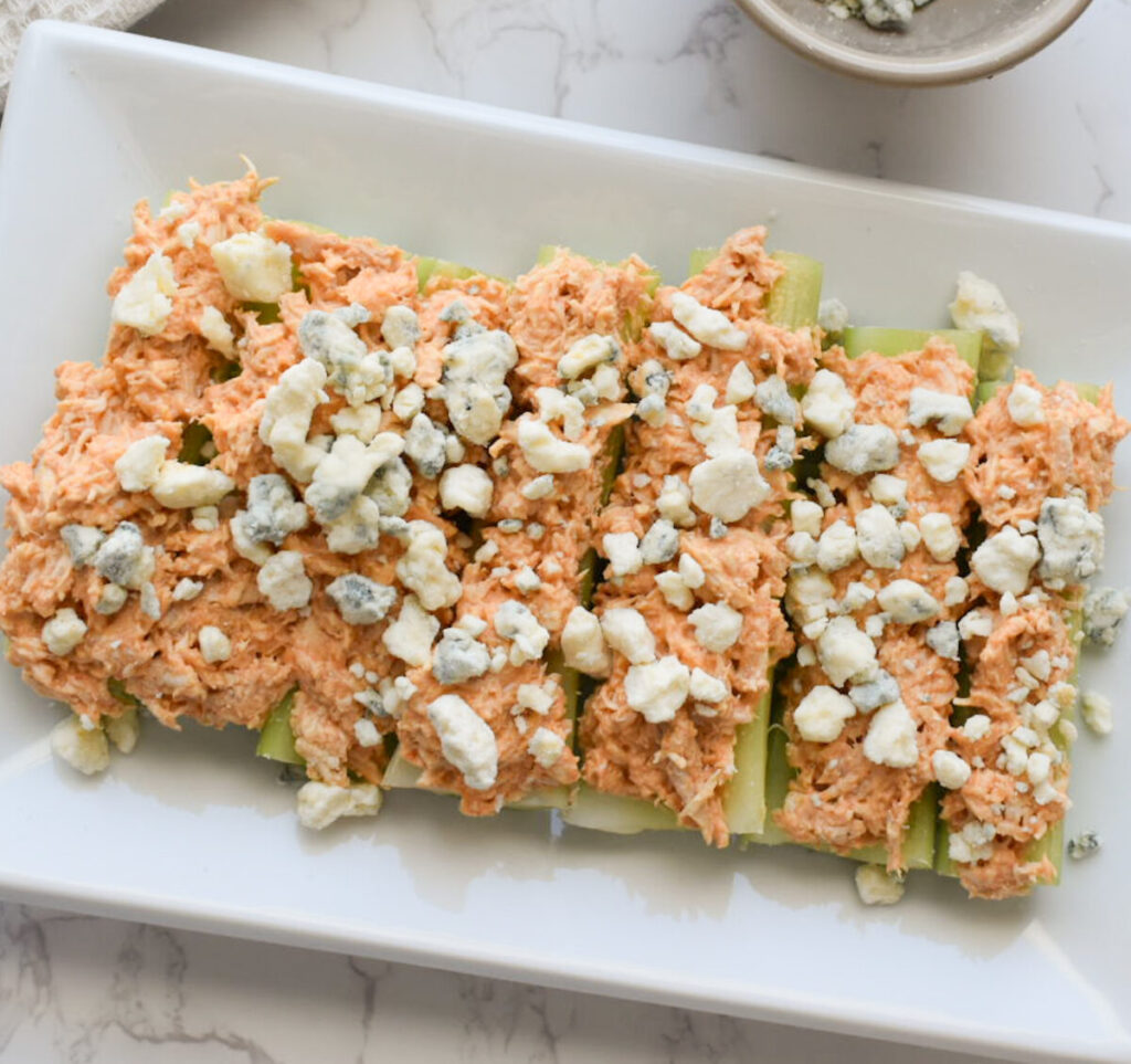 buffalo chicken over celery sticks topped with bleu cheese