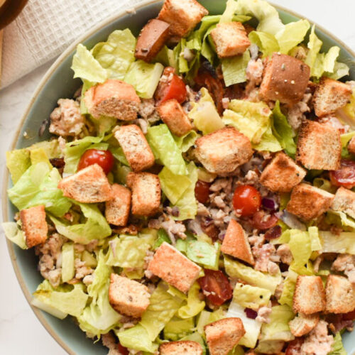 deconstructed burger bowl with fresh veggies, meat, and homemade dressing